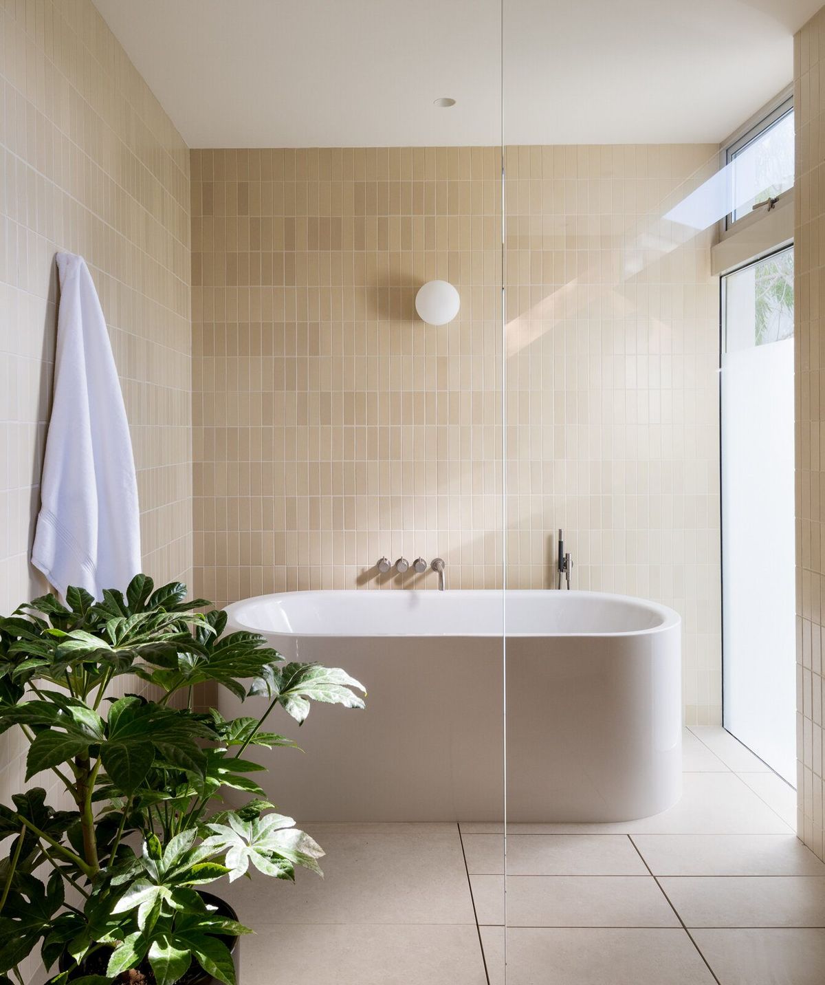 Altair: Primary bath with a freestanding tub, stone-tile walls and a skylight