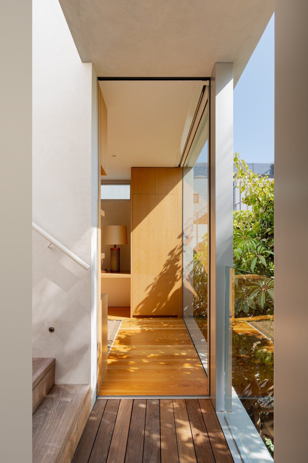 Altair: Narrow glazed passage between fir walls opening onto the wood deck