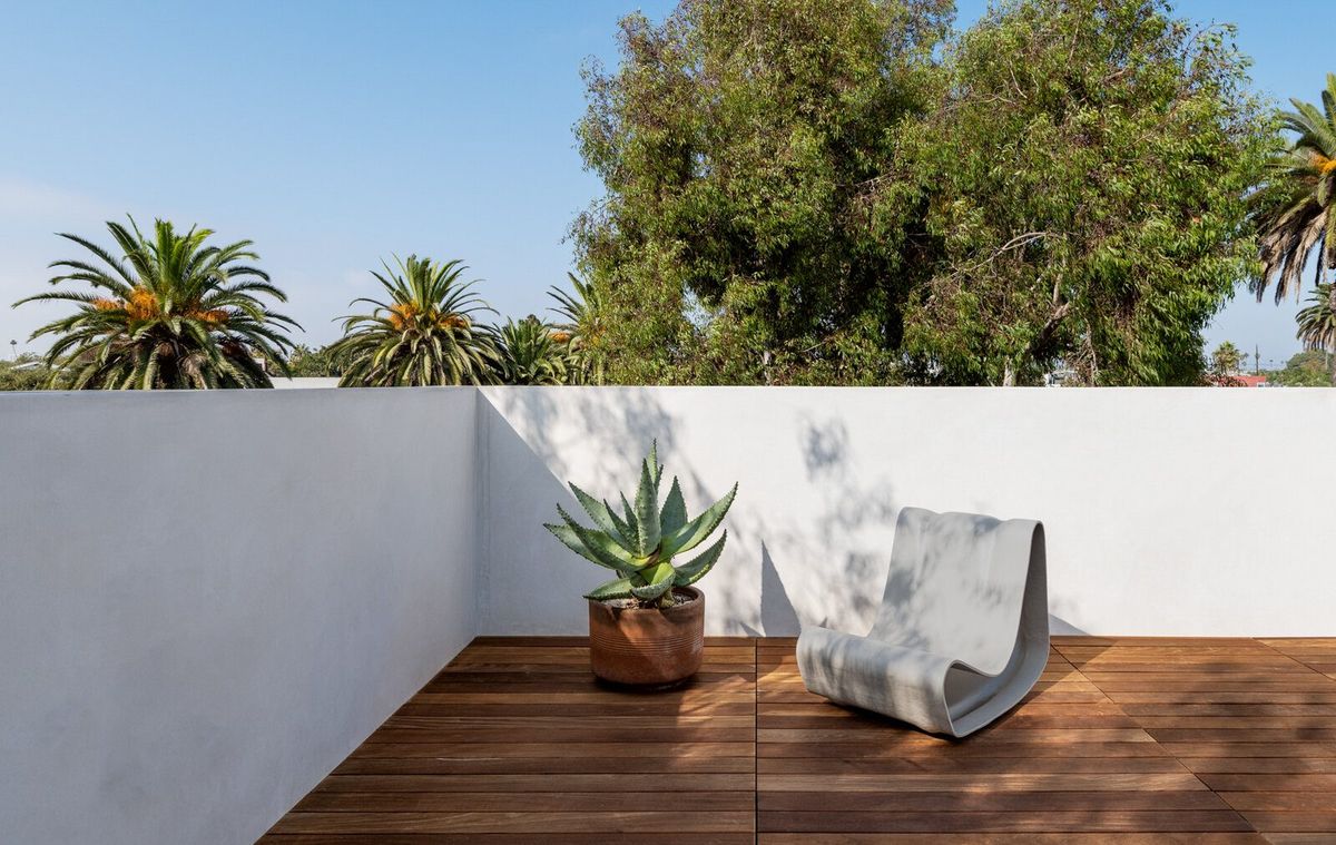Altair: Roof deck with ipe decking, white parapet walls and palm views
