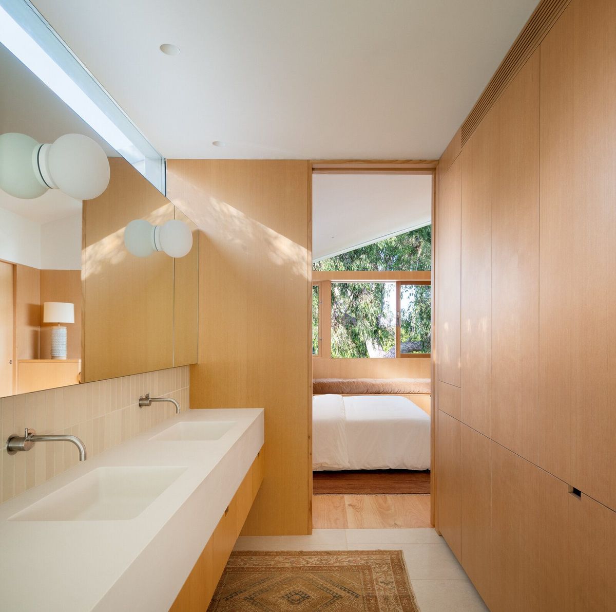 Altair: Fir-paneled bath with a double trough sink and globe lights, bedroom beyond