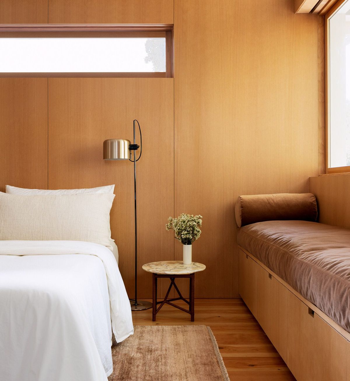 Altair: Fir-paneled bedroom with a built-in daybed and brass floor lamp