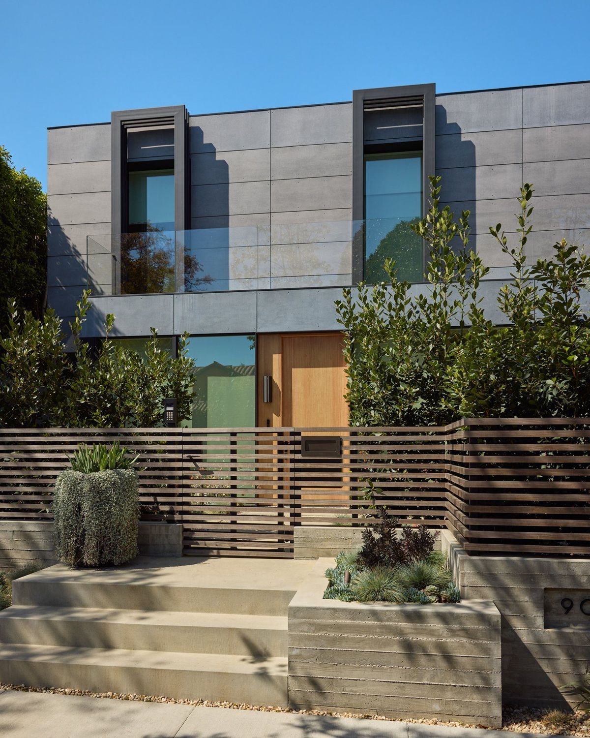 Ashcroft: Modern two-story facade clad in gray panels behind a horizontal slat fence