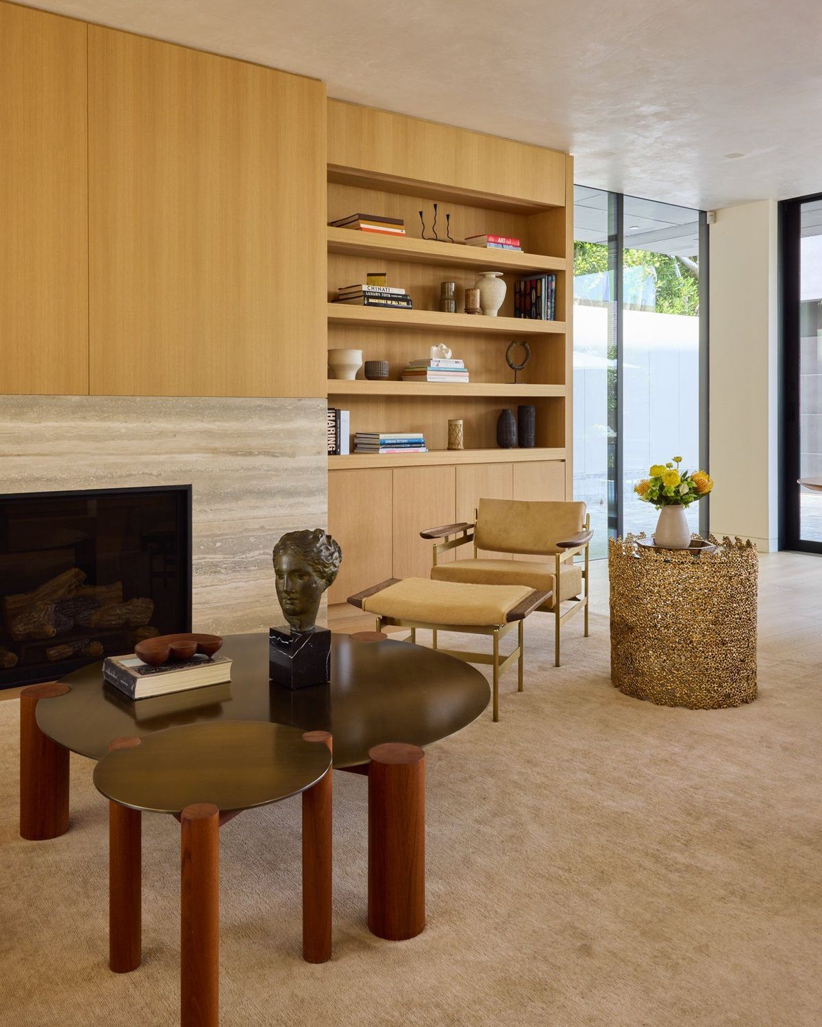 Ashcroft: Living room with travertine fireplace surround, oak shelving and sculptural seating