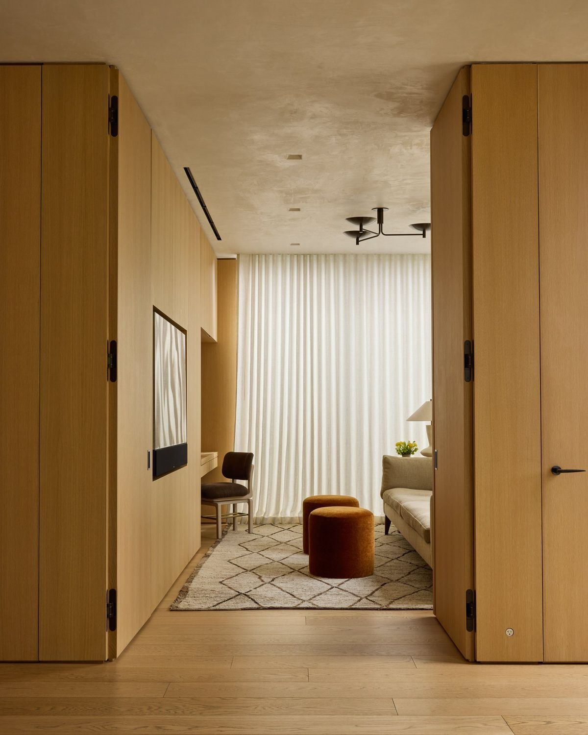 Ashcroft: Oak pocket doors opening into a sitting room with sheer curtains