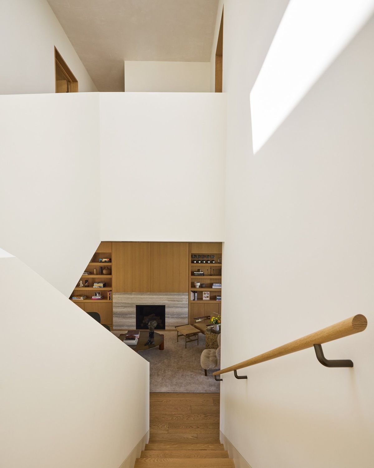 Ashcroft: White stairwell with an oak handrail looking down to the living room