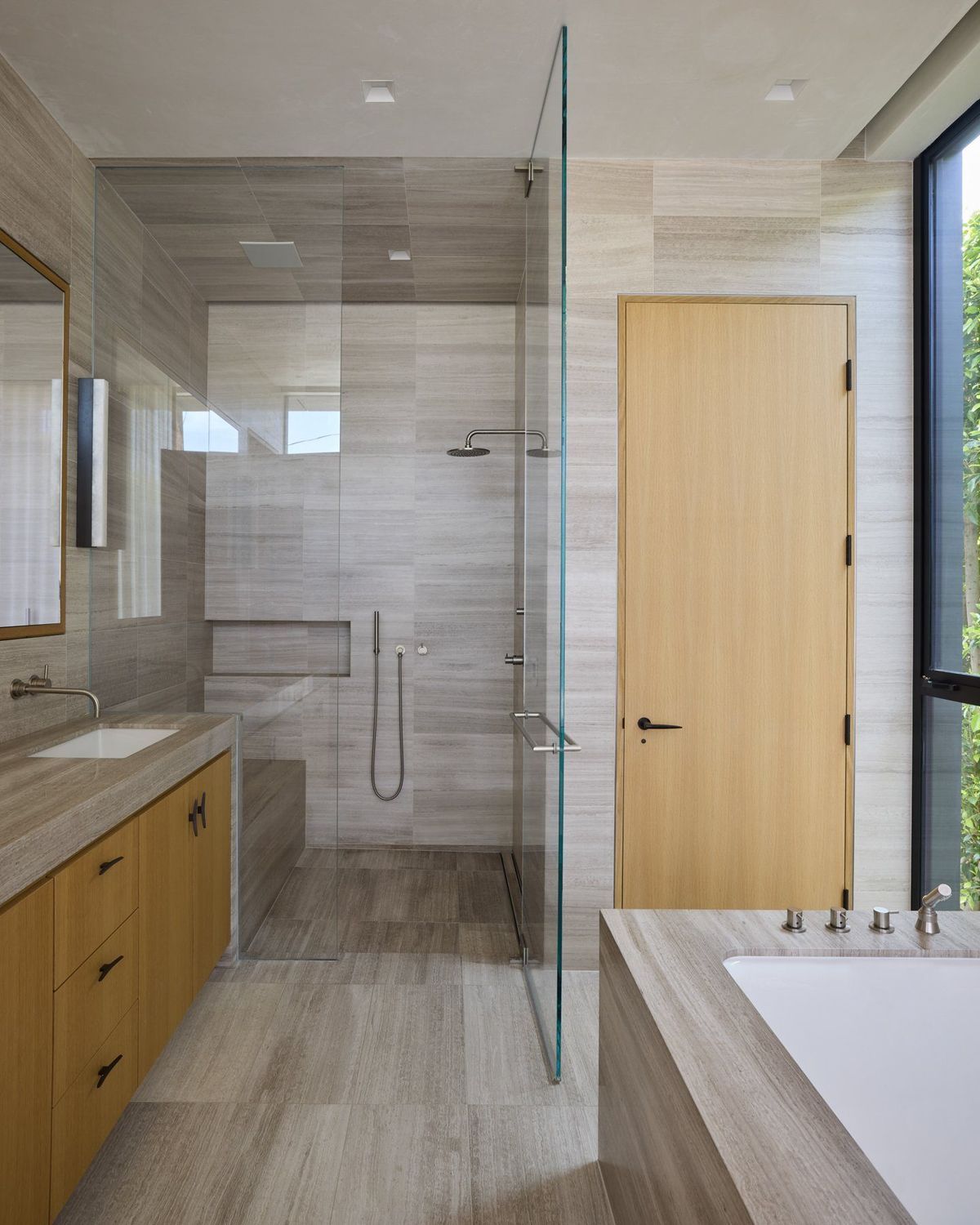 Ashcroft: Bathroom with a glass shower, gray stone tile and oak vanity