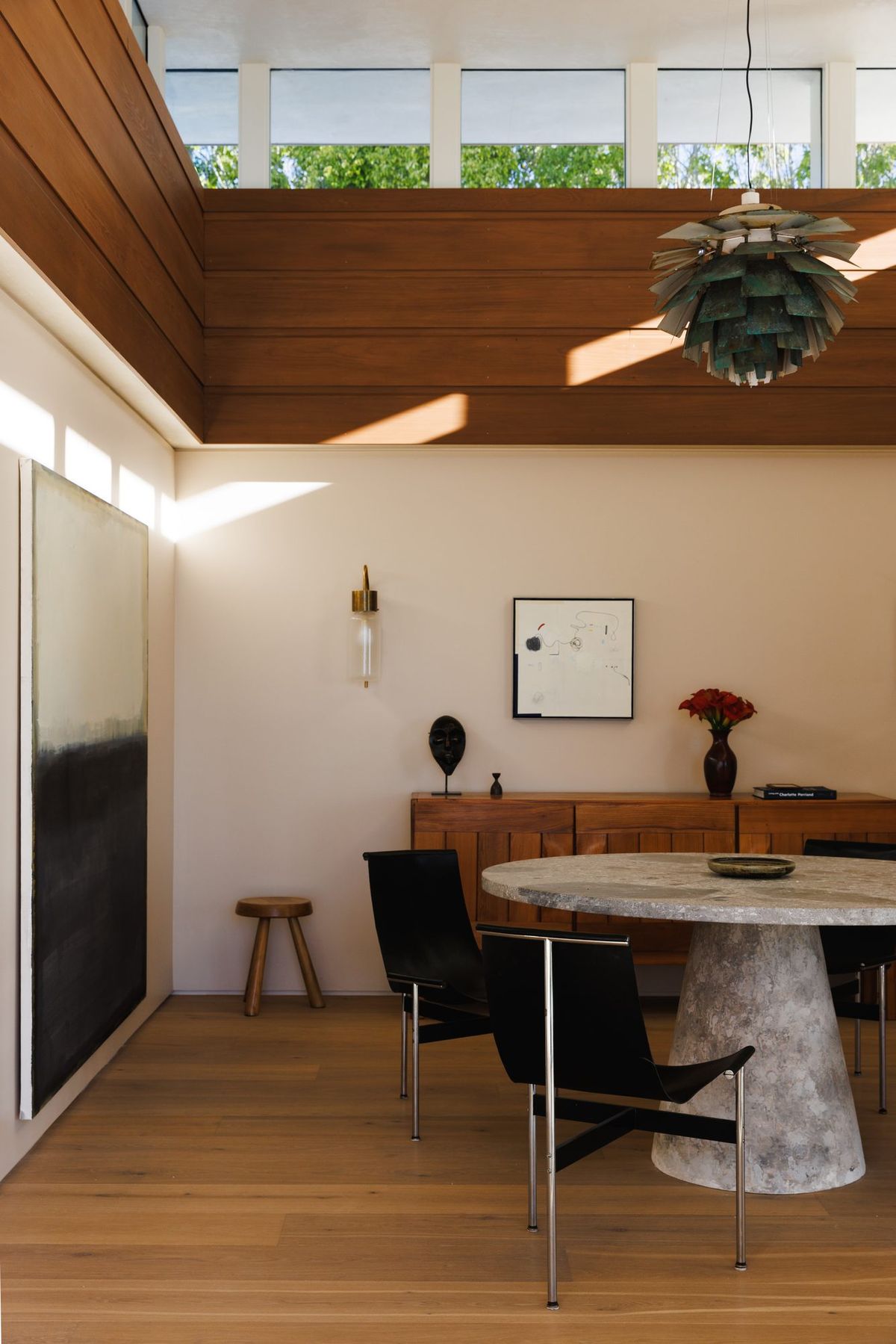 Carla Ridge: Dining nook with a pedestal table under a wood ceiling and clerestory