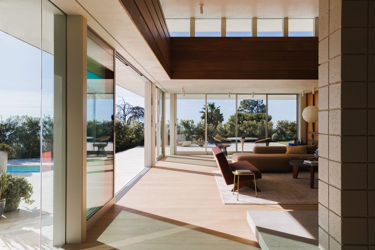 Carla Ridge: Glass-walled living room opening to the pool terrace and hillside view