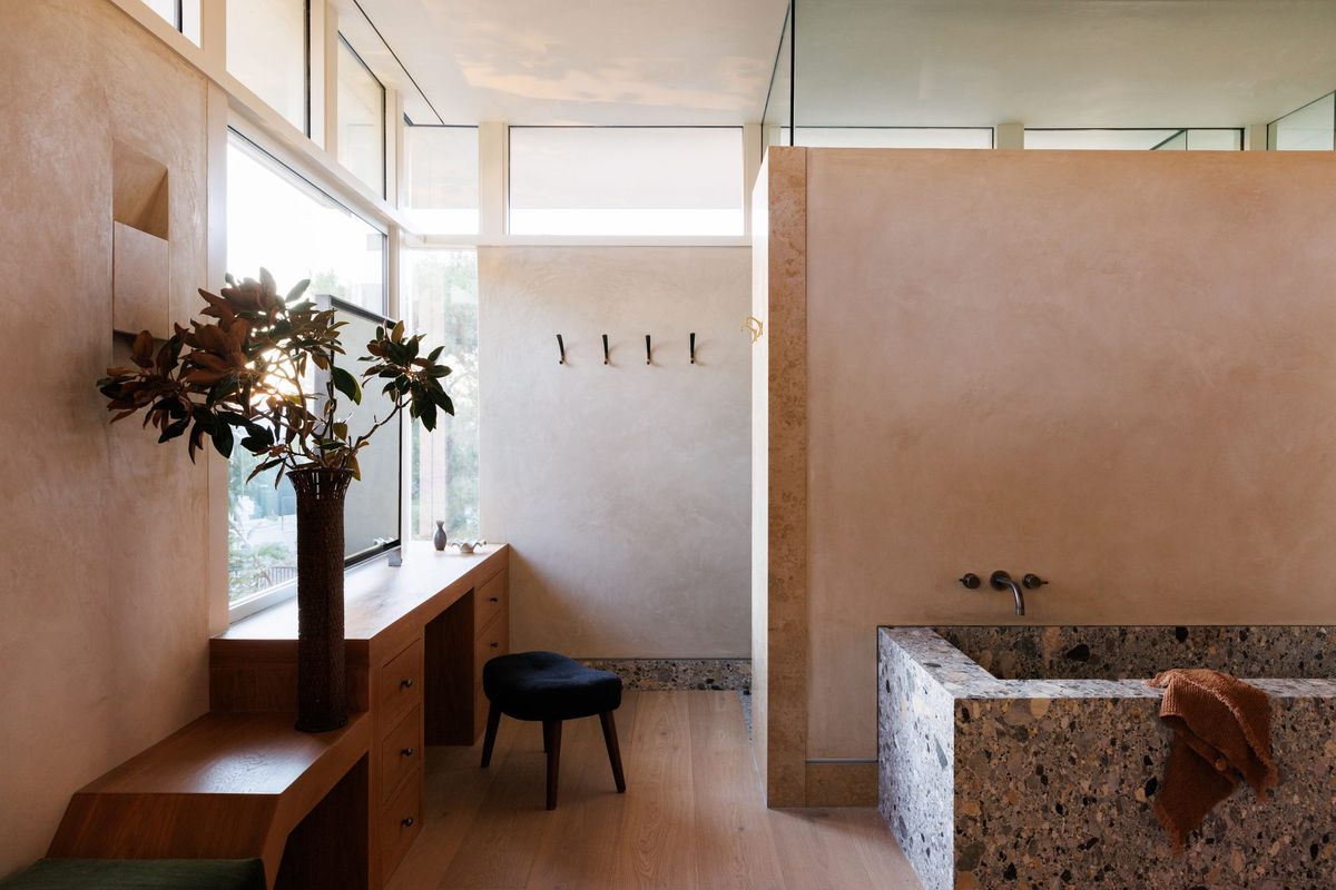 Carla Ridge: Primary bath with plaster walls, a terrazzo soaking tub and wood vanity