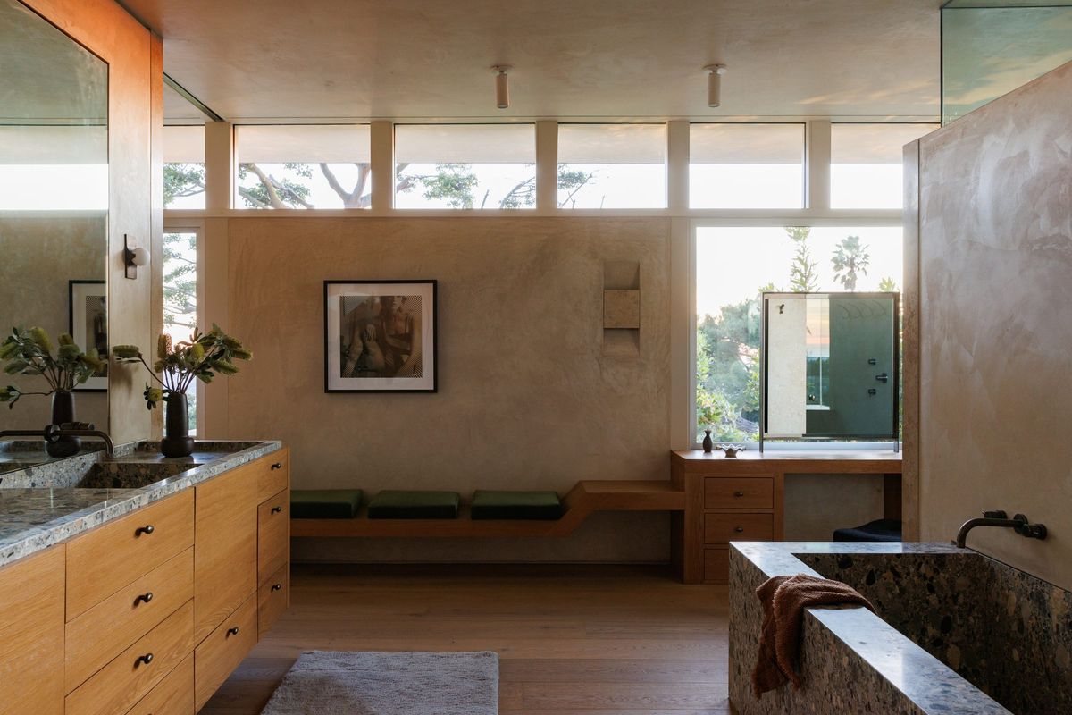 Carla Ridge: Bath with a long wood vanity, plaster walls and clerestory light