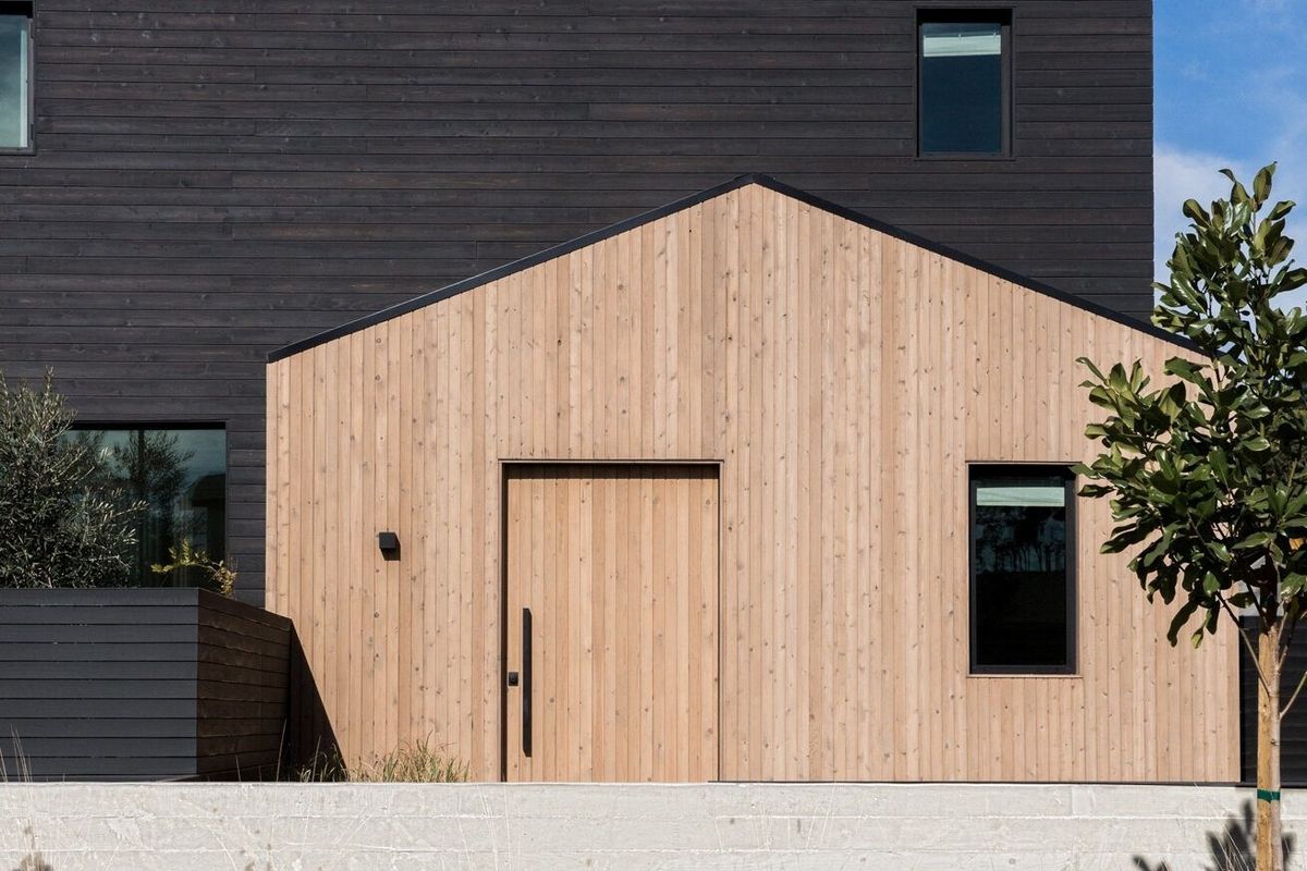 Flower: Modern farmhouse with a wood-clad gable in front of a black-clad two-story volume