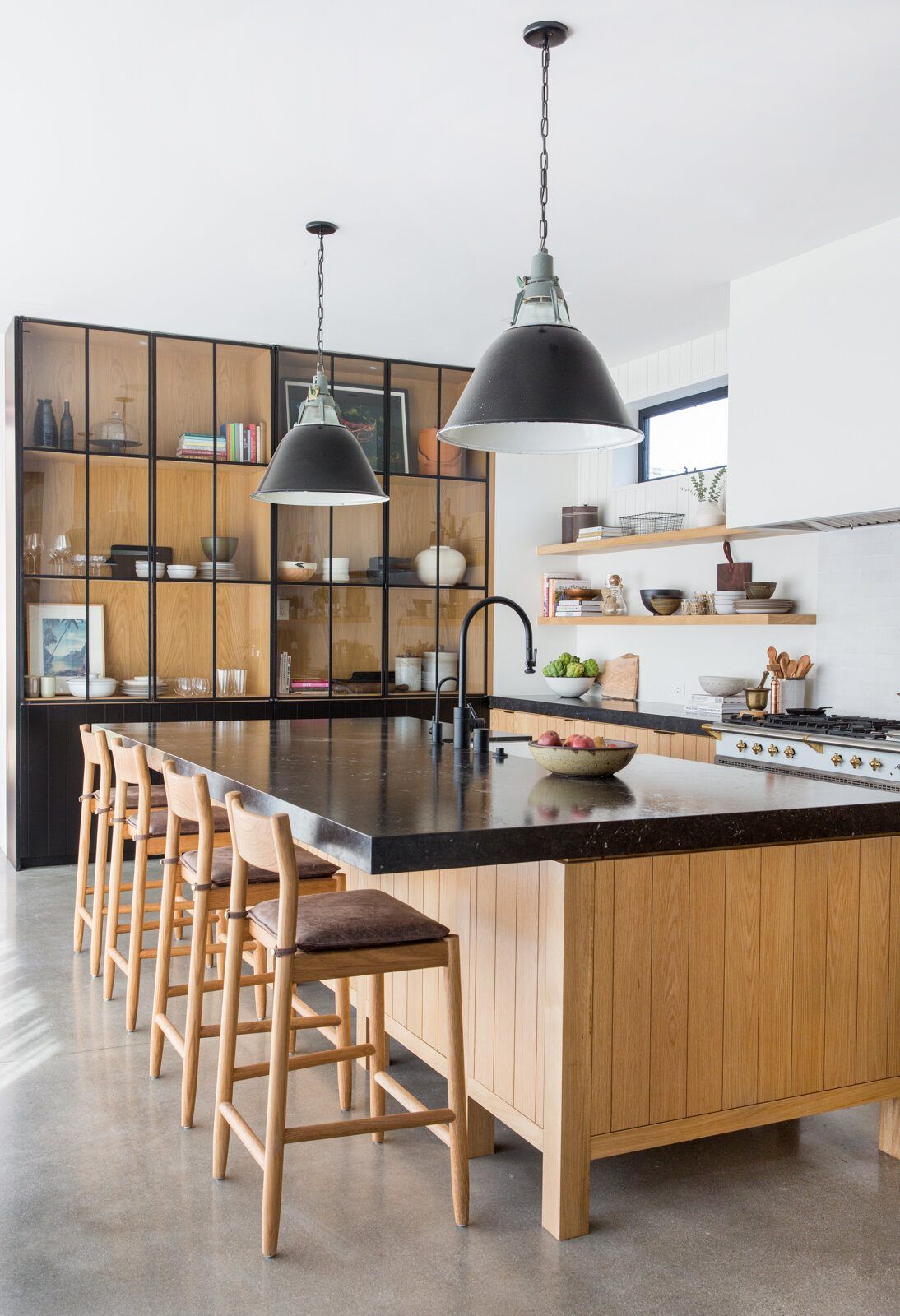 Flower: Kitchen with an oak island, black counters and industrial pendants