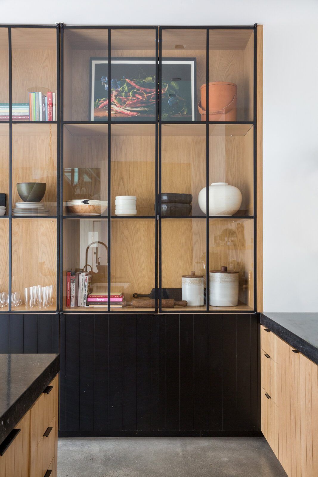 Flower: Steel-framed glass cabinet with oak shelving above black lower cabinets