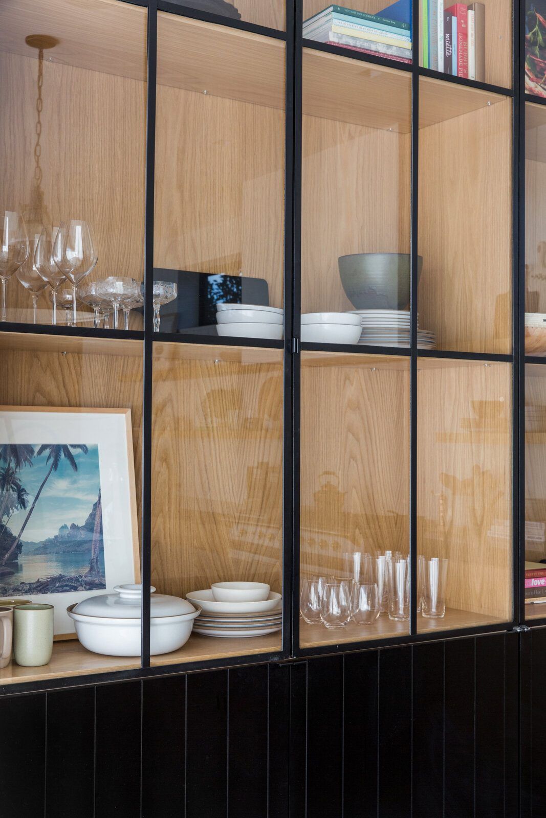 Flower: Black steel-and-glass cabinet with oak shelves holding glassware