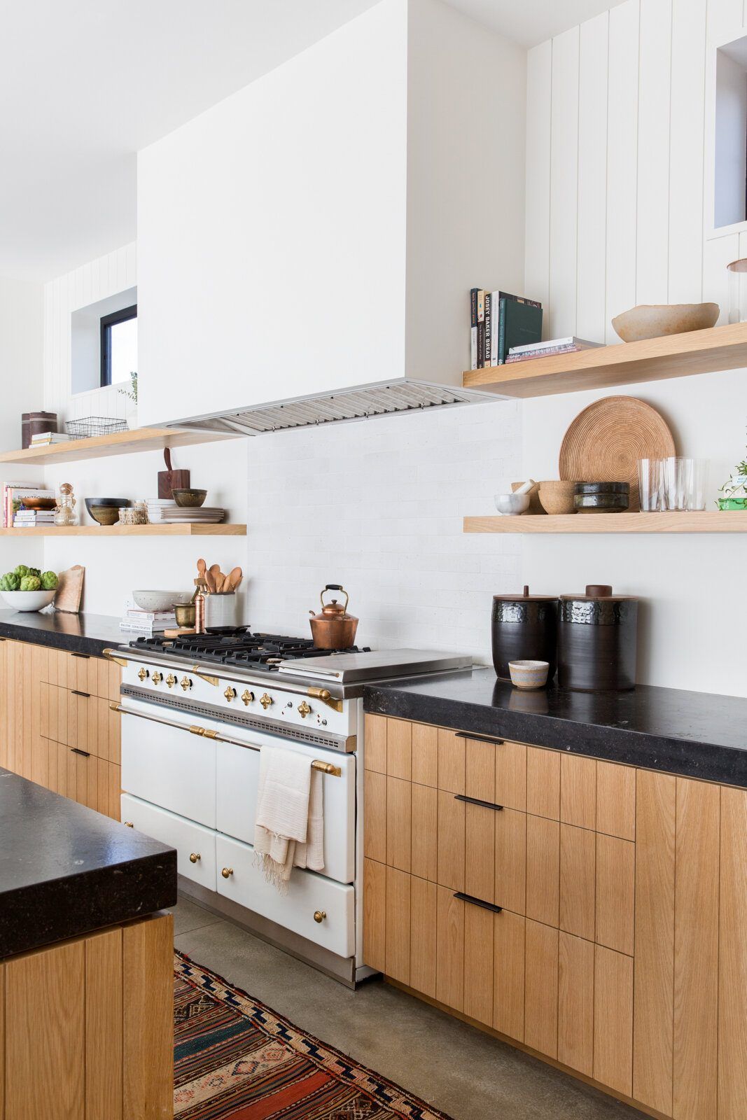 Flower: Kitchen with oak cabinets, black counters, white range and open shelves