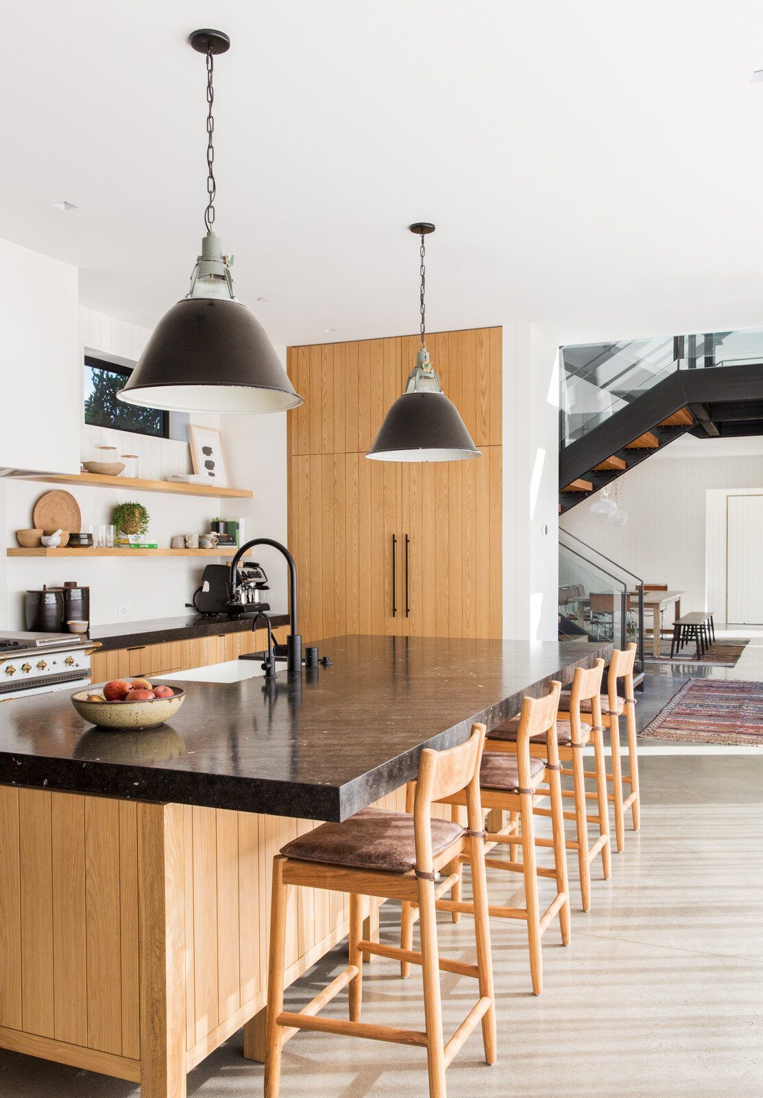 Flower: Kitchen island with counter stools and black pendants, stair beyond