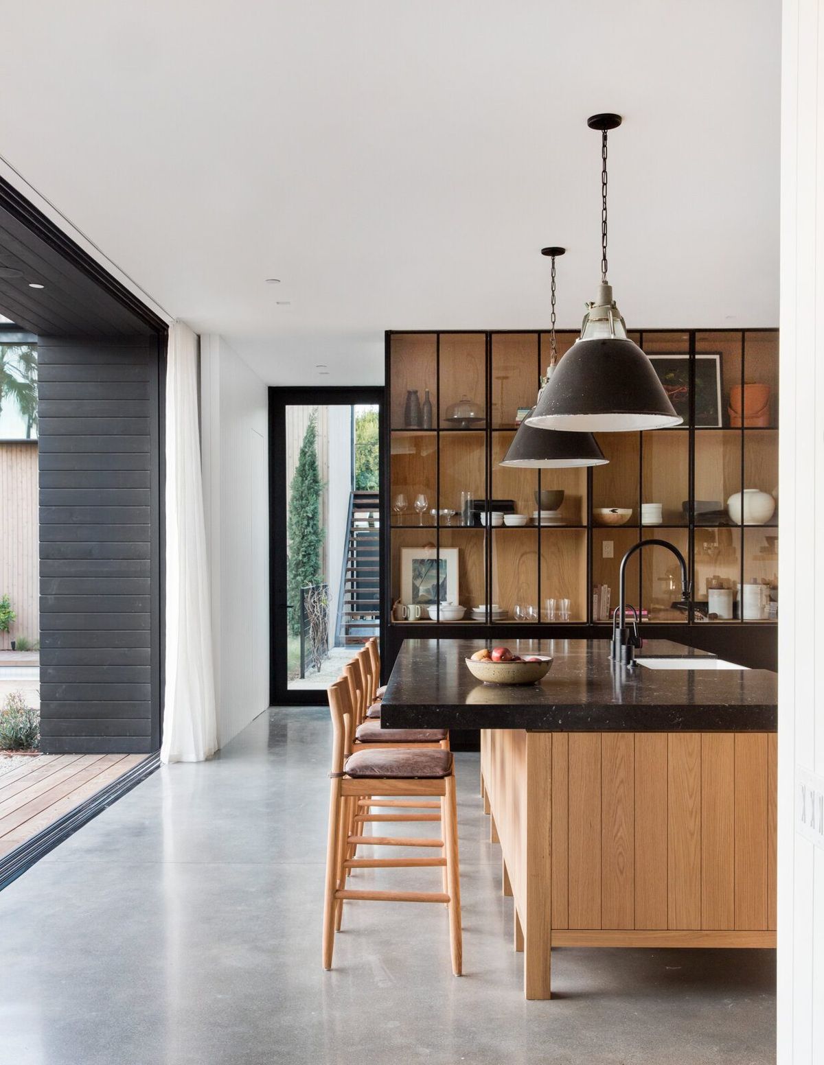 Flower: Open kitchen with oak island stools under black pendants