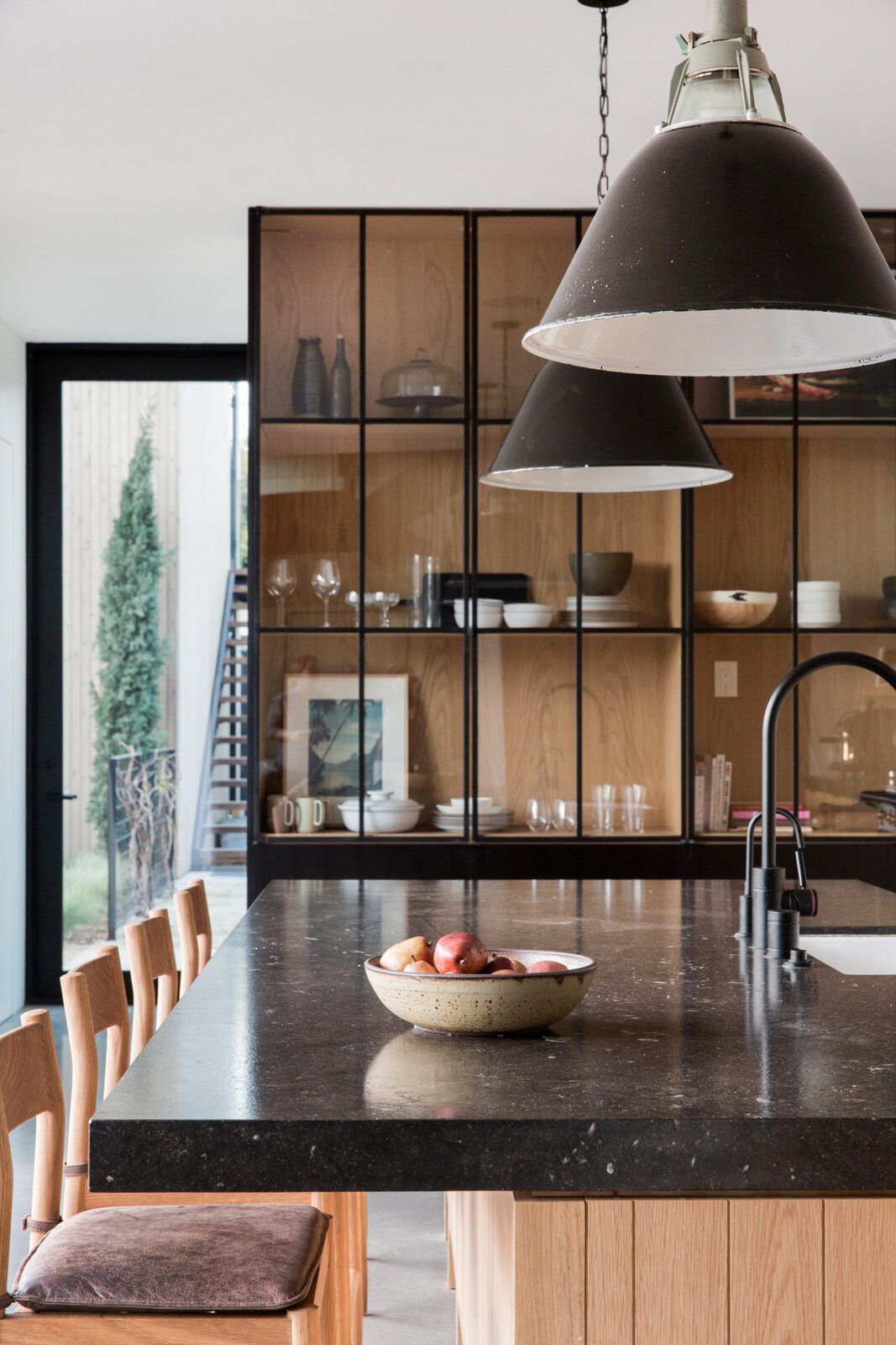Flower: Black granite island and steel-framed glass shelving under a black pendant