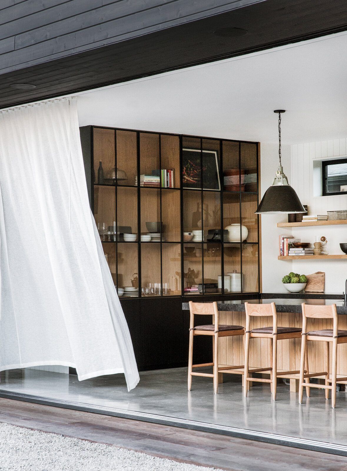 Flower: Sheer curtain blowing across the open kitchen wall