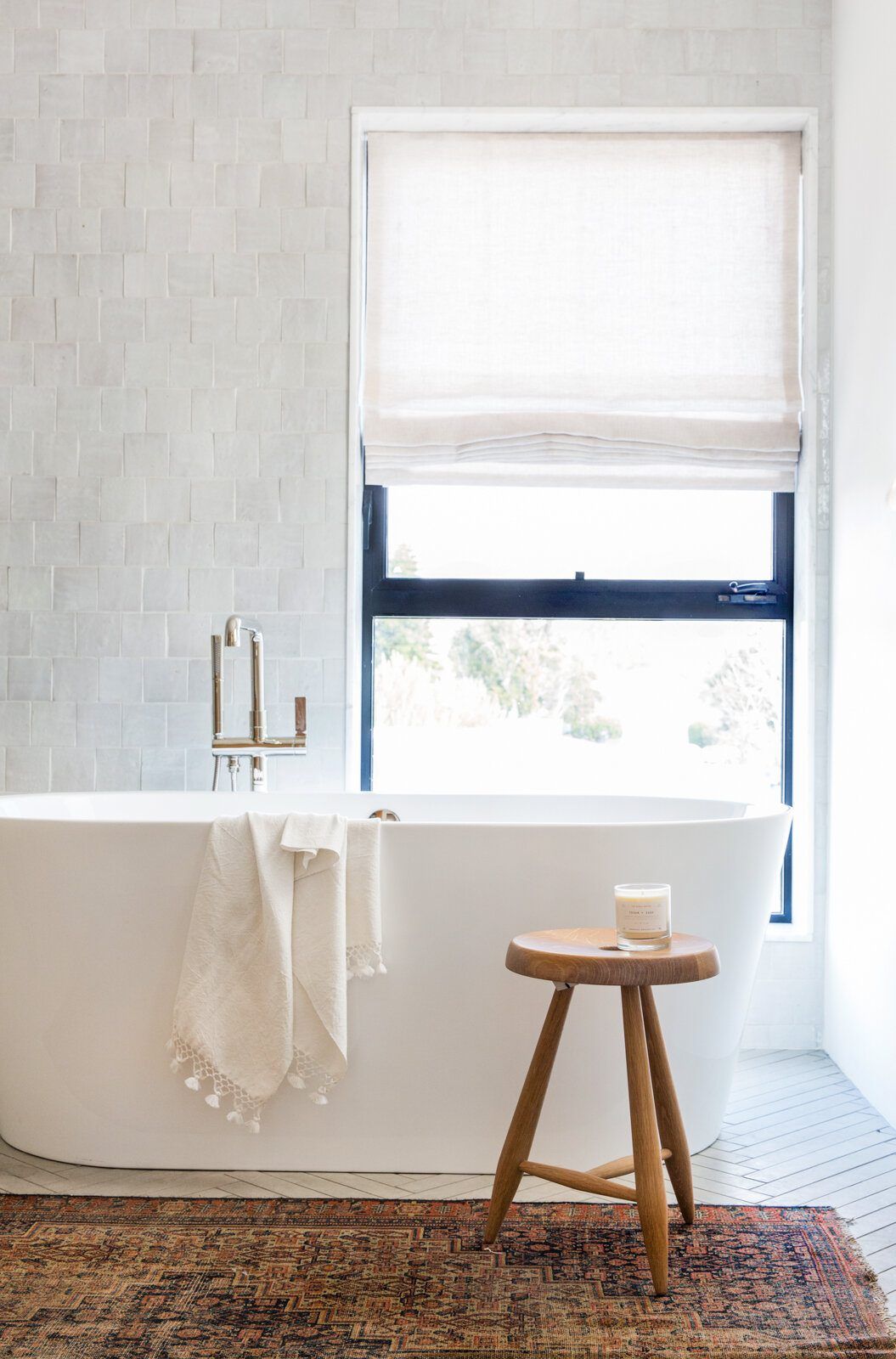 Flower: Freestanding tub beneath a window with a wood stool