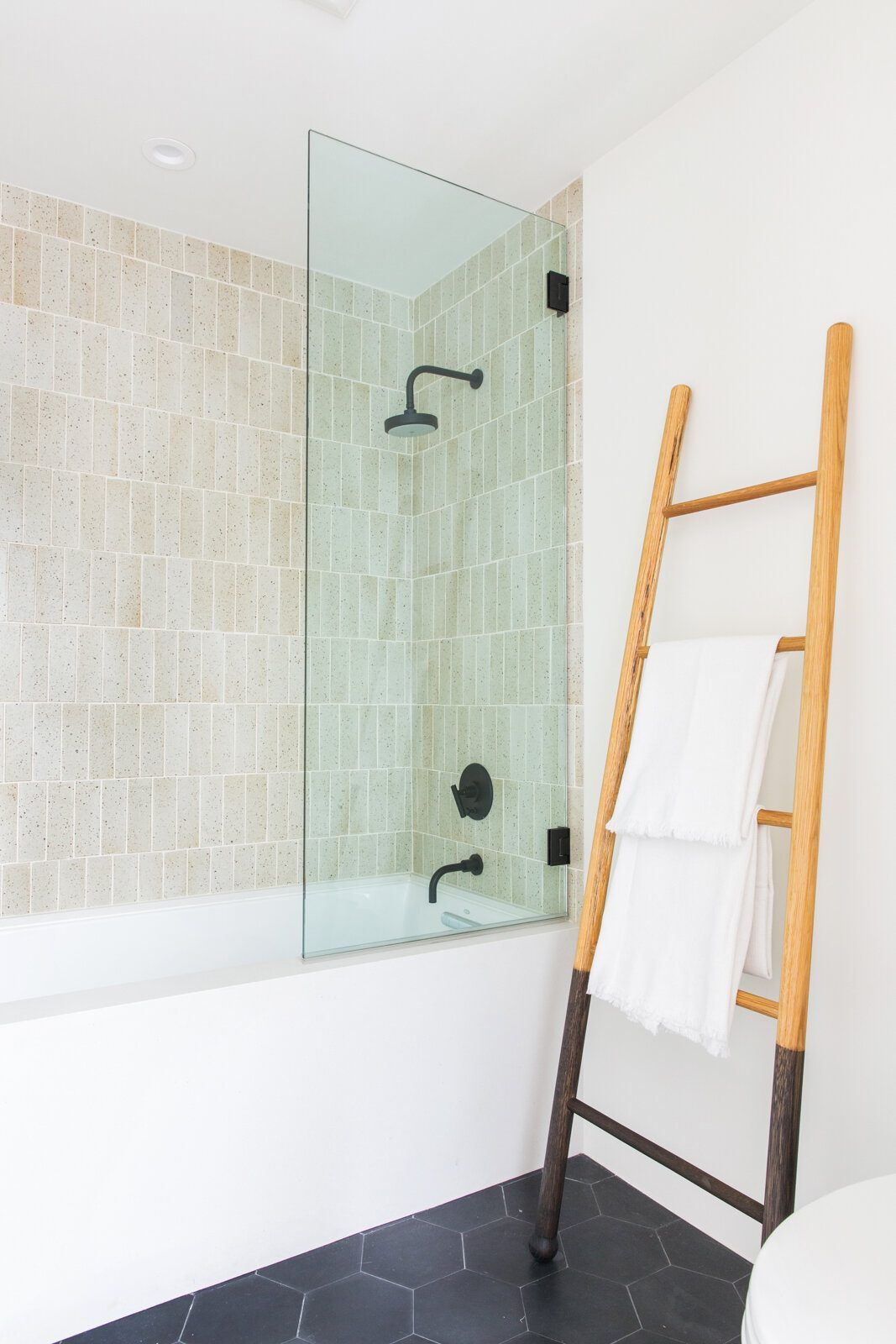 Flower: Shower with glass screen, tile walls and a wood towel ladder