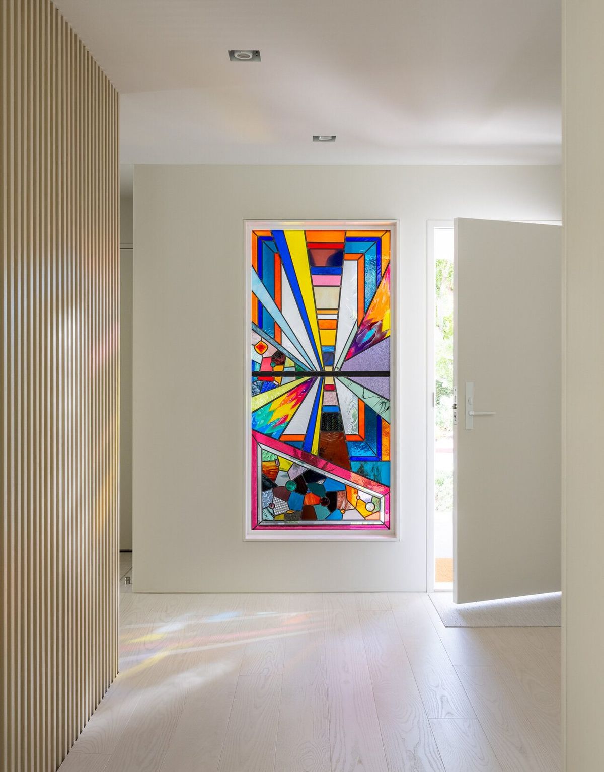 Harbor: Entry with a vertical oak slat screen and a vivid geometric artwork