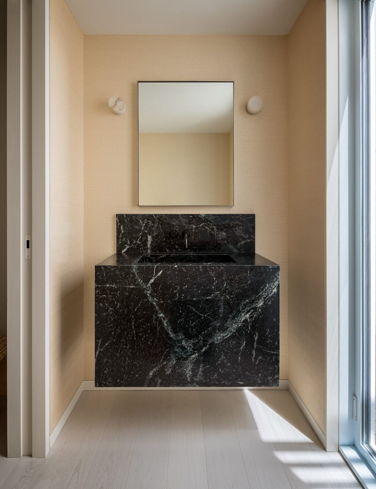 Harbor: Powder room with a dark marble block sink in an oak alcove