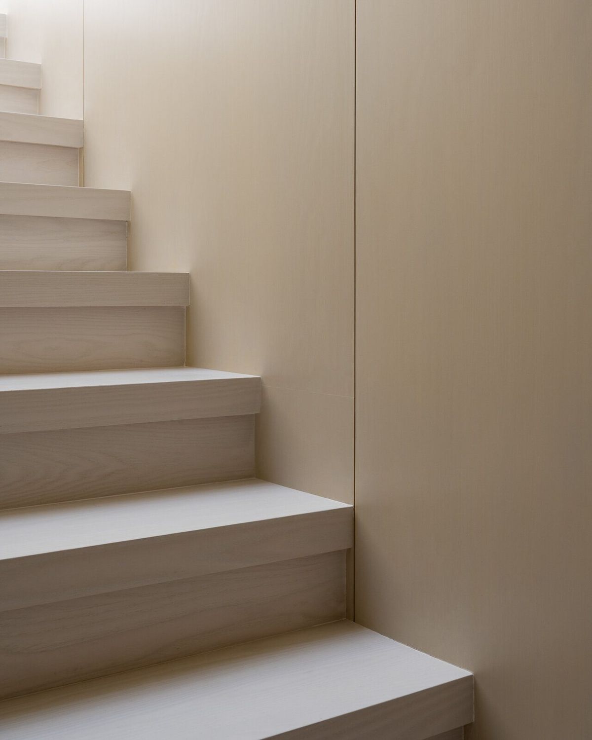 Harbor: Pale oak stair rising beside a plain wall