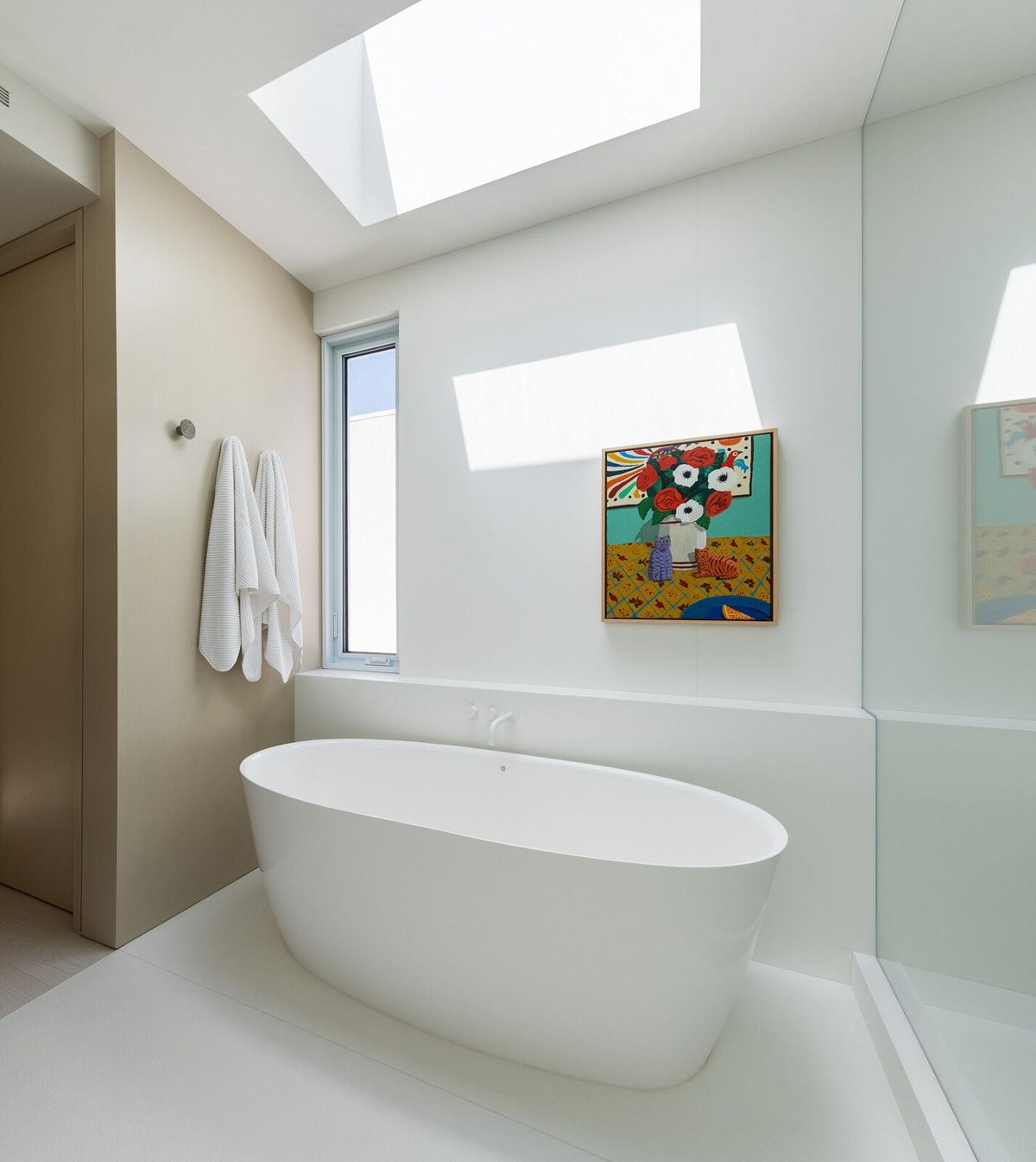 Harbor: Skylit bath with a freestanding tub and bright artwork
