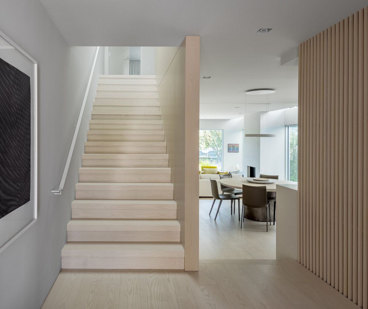 Harbor: Pale oak stair beside an oak slat screen, dining area beyond