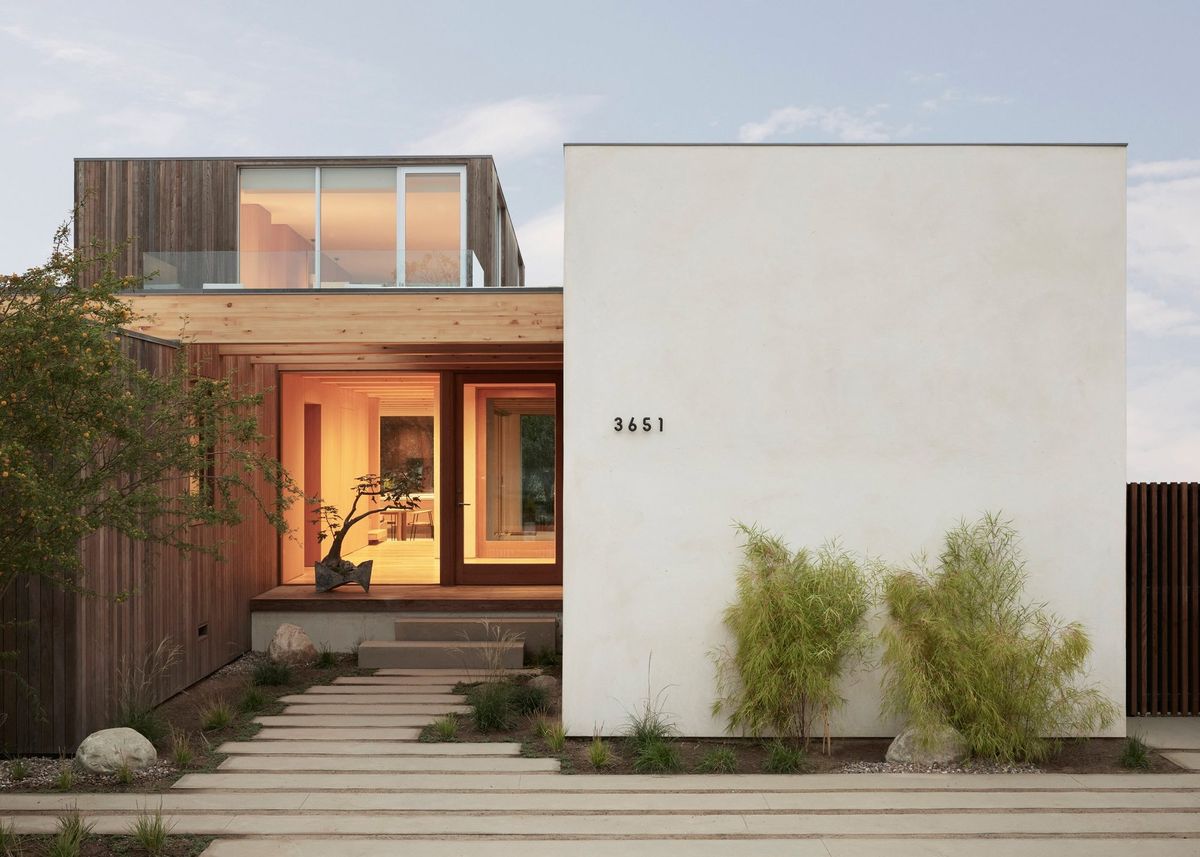 Meier: Entry walk of concrete pavers to a glowing wood-framed entrance