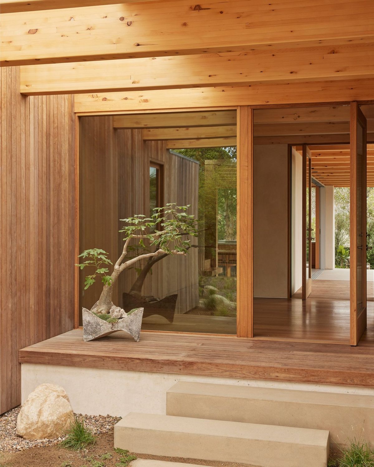 Meier: Entry porch with a bonsai, wood-framed glass doors and stone steps