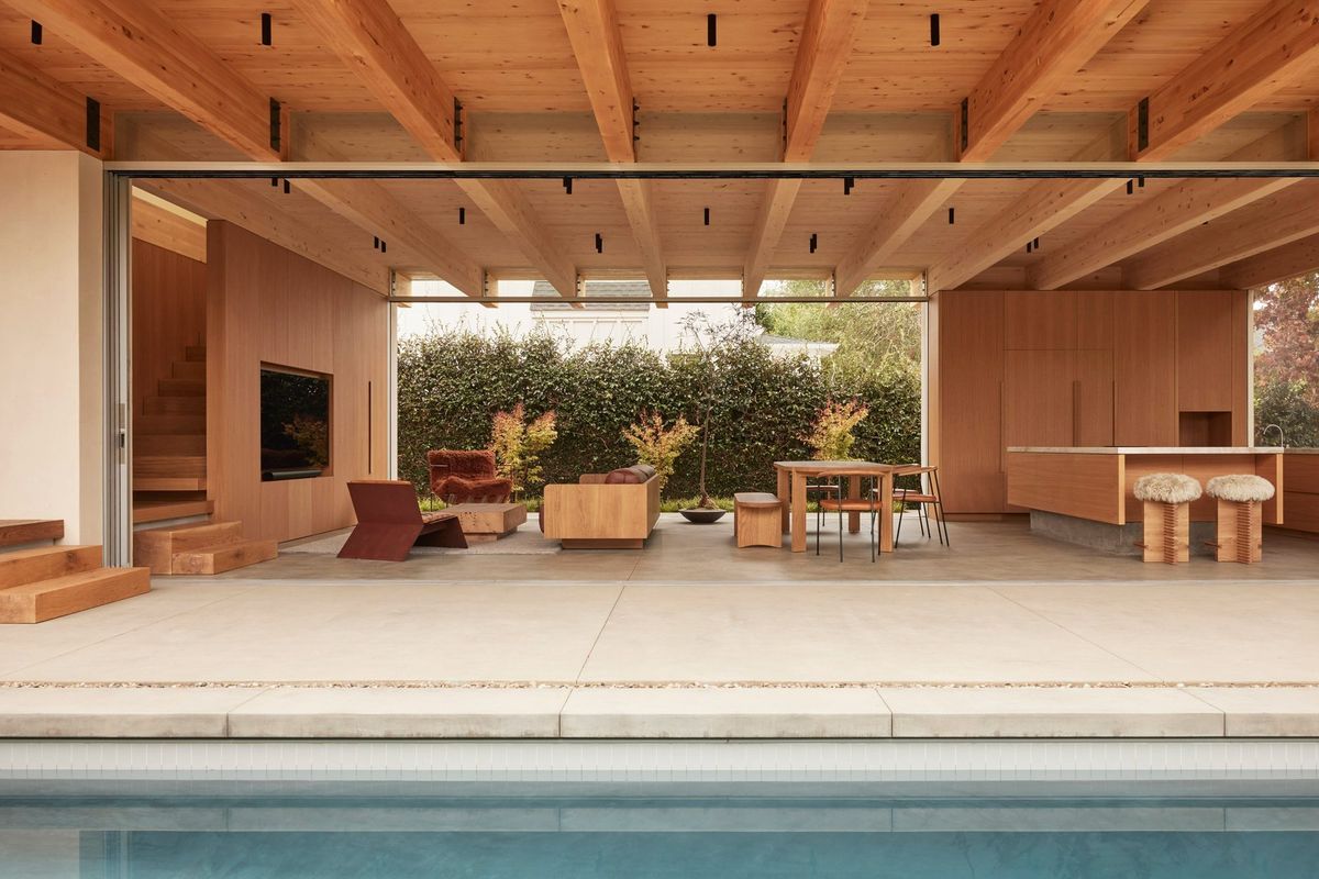 Meier: Living spaces under a heavy glulam beam ceiling opening to the pool