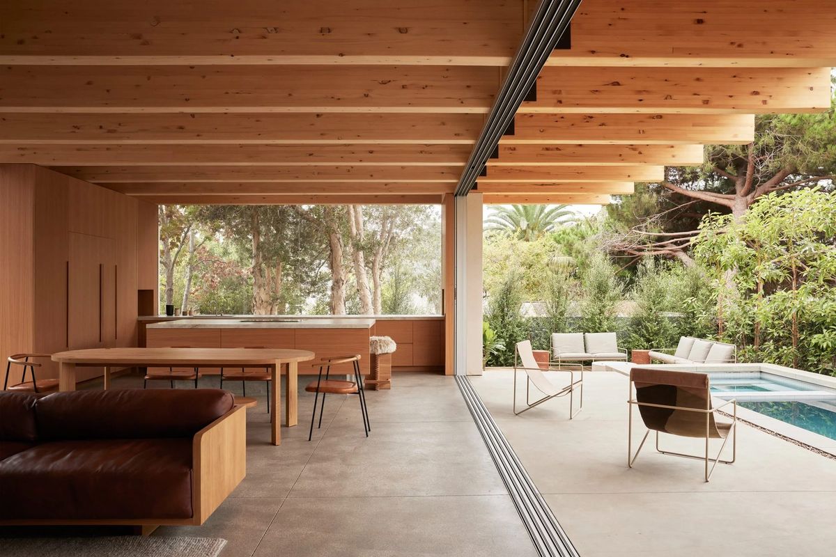 Meier: Open living and dining pavilion under glulam beams with the pool and garden