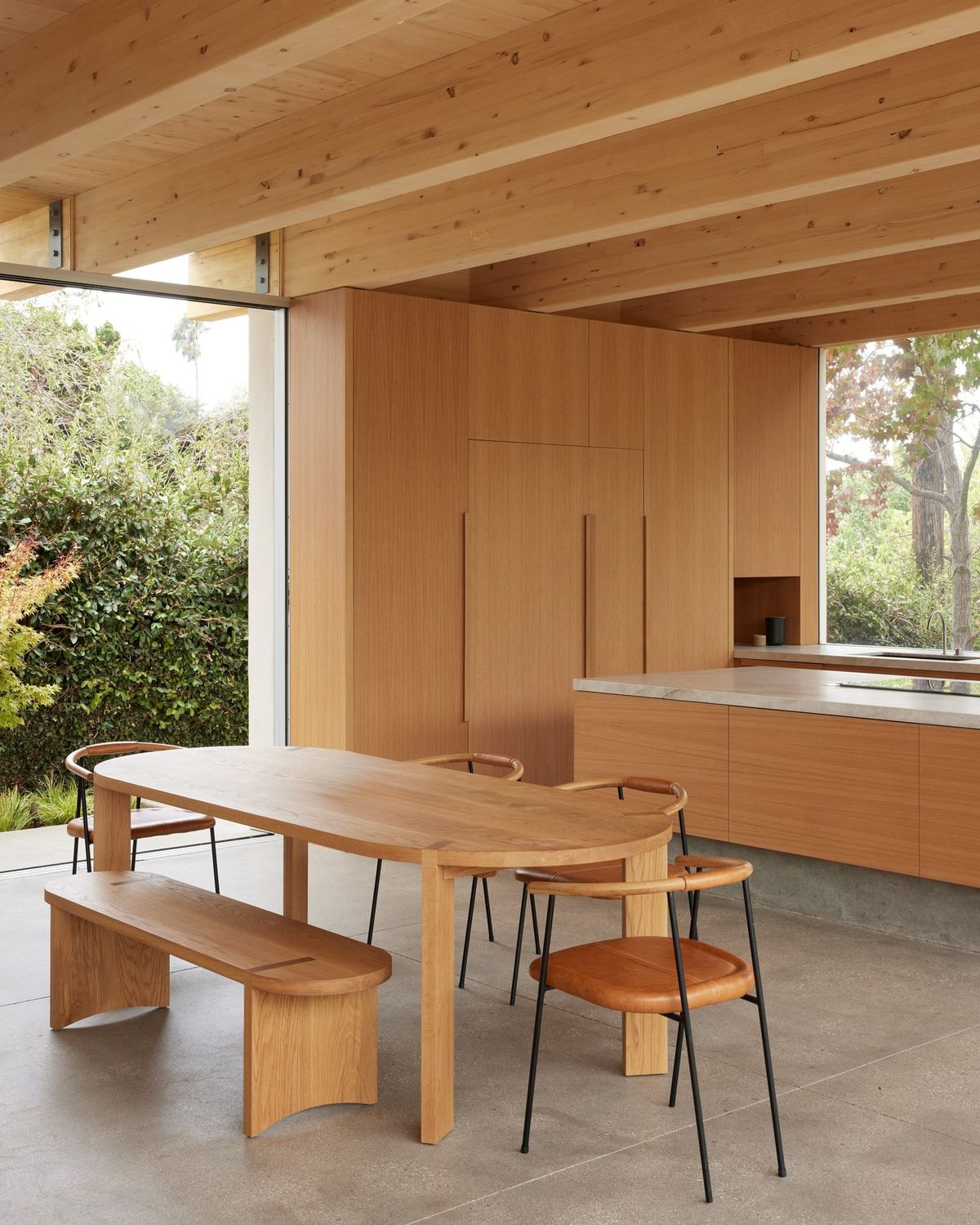 Meier: Dining table and bench under glulam beams beside the kitchen