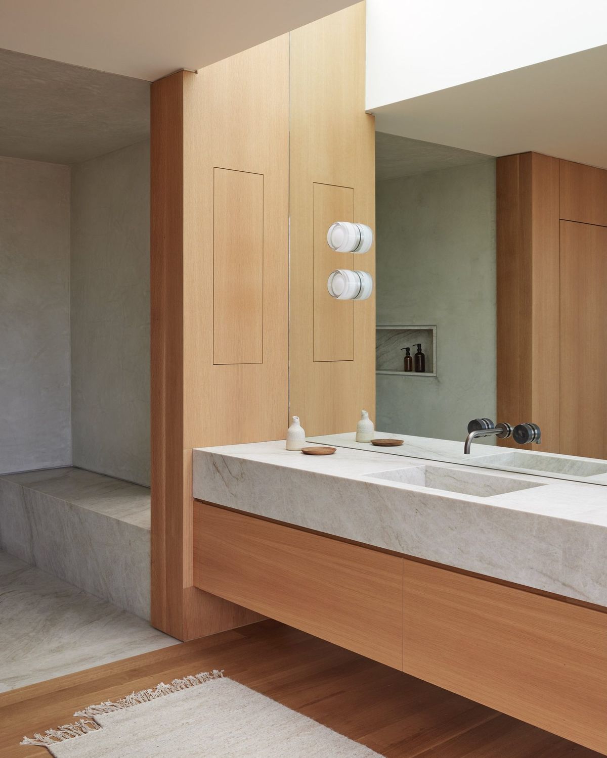Meier: Bath with a stone vanity, wood cabinetry and plaster shower