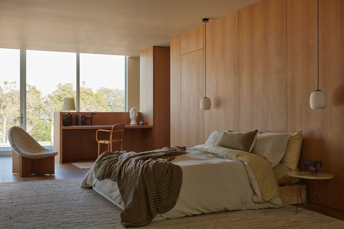 Meier: Primary bedroom with wood-paneled walls and pendant lights