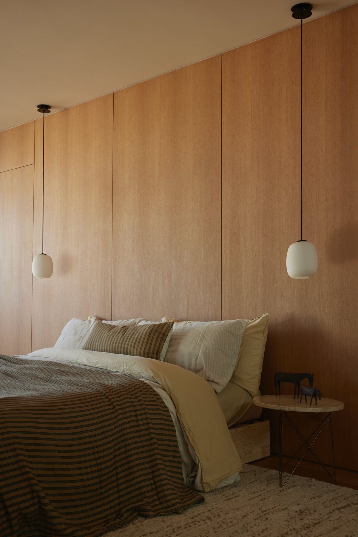Meier: Wood-paneled bedroom wall with pendant lights over the bed