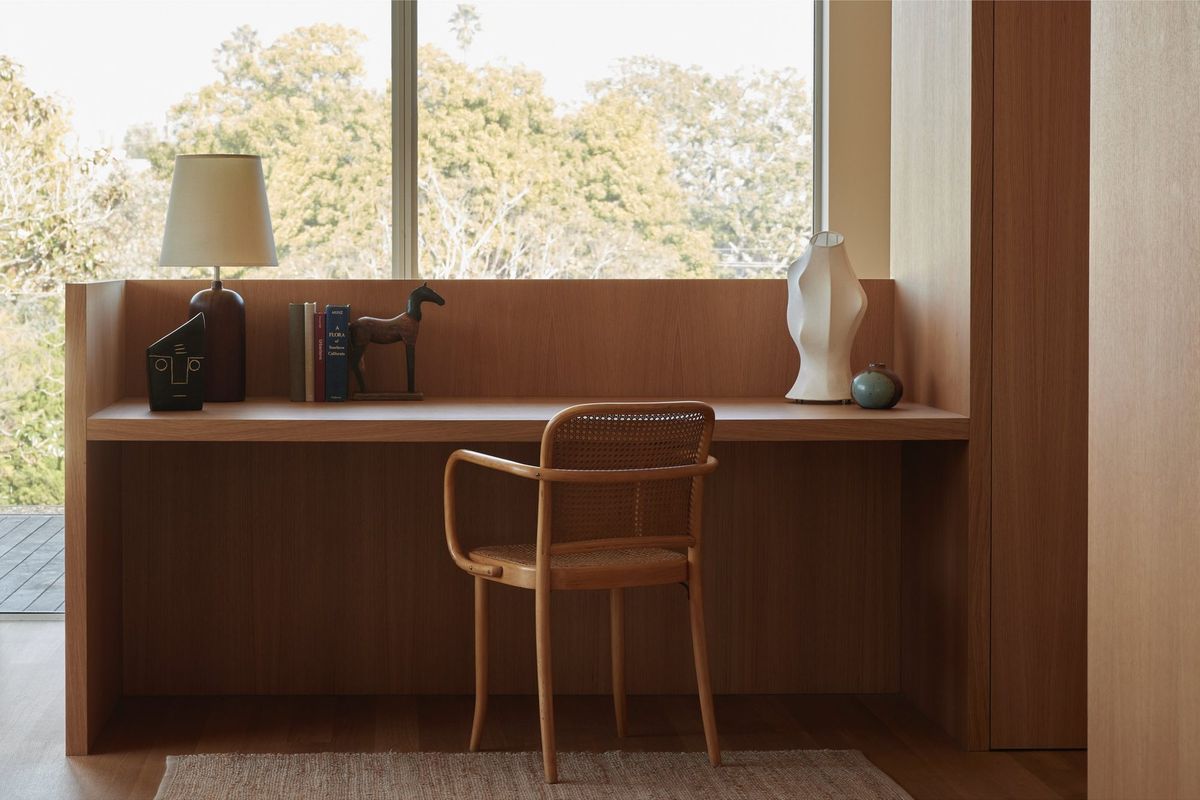 Meier: Built-in wood desk beneath a window with a bentwood chair