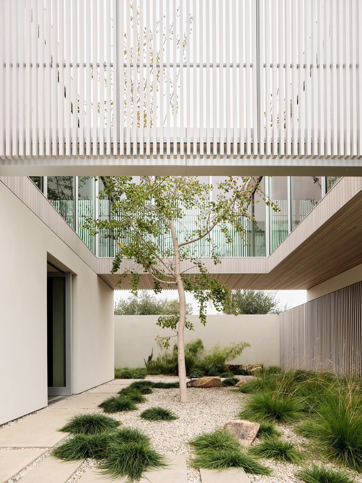 Modjeska: Gravel courtyard with a young tree under the upper floor