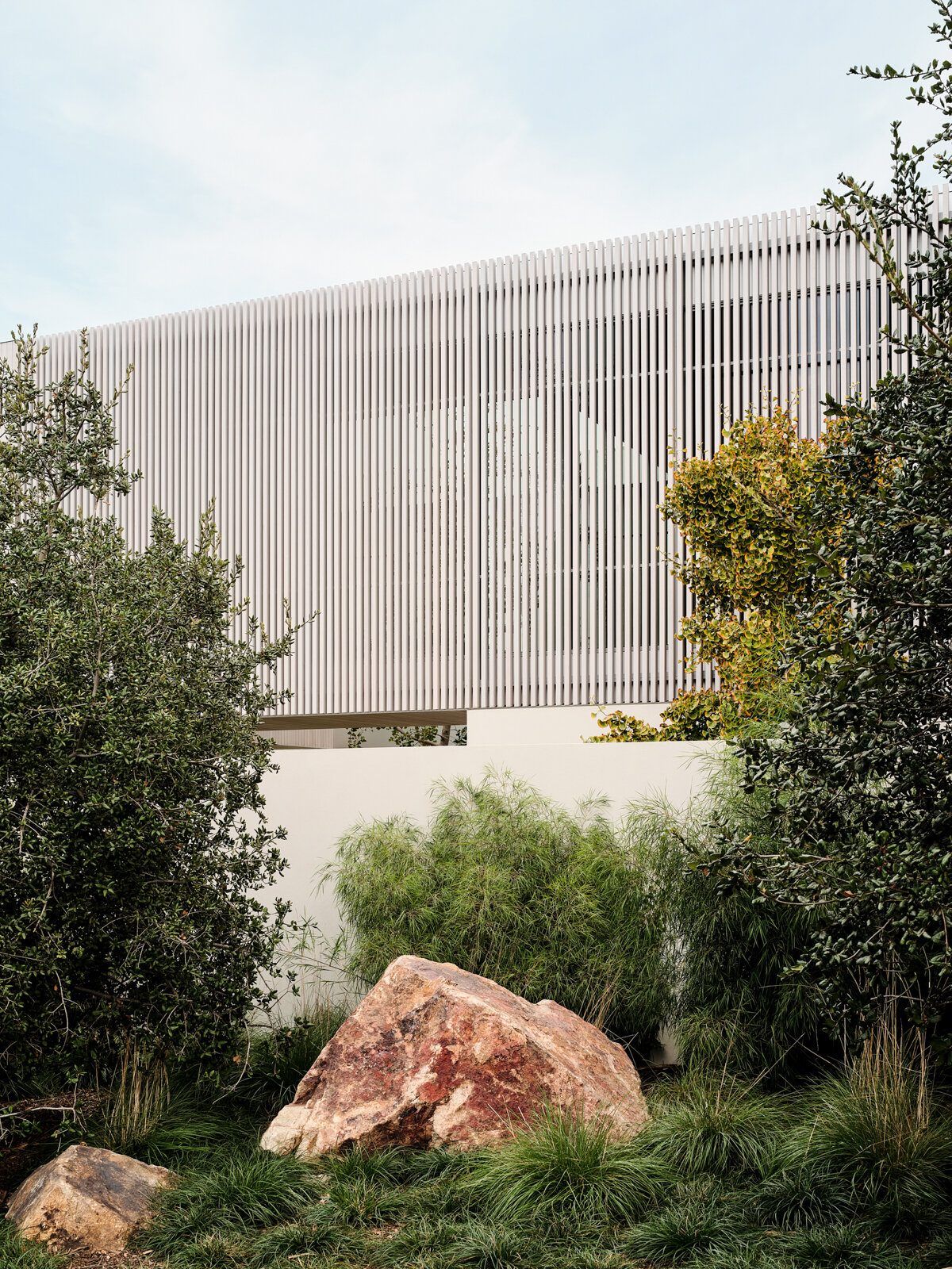 Modjeska: Boulders and native planting below the louvered upper floor
