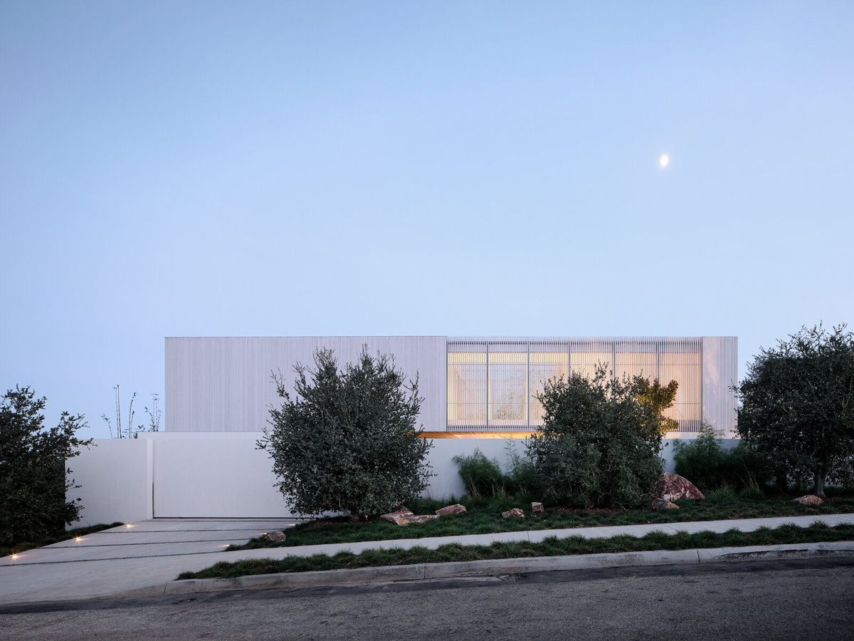 Modjeska: House at dusk behind olive trees and a low white wall