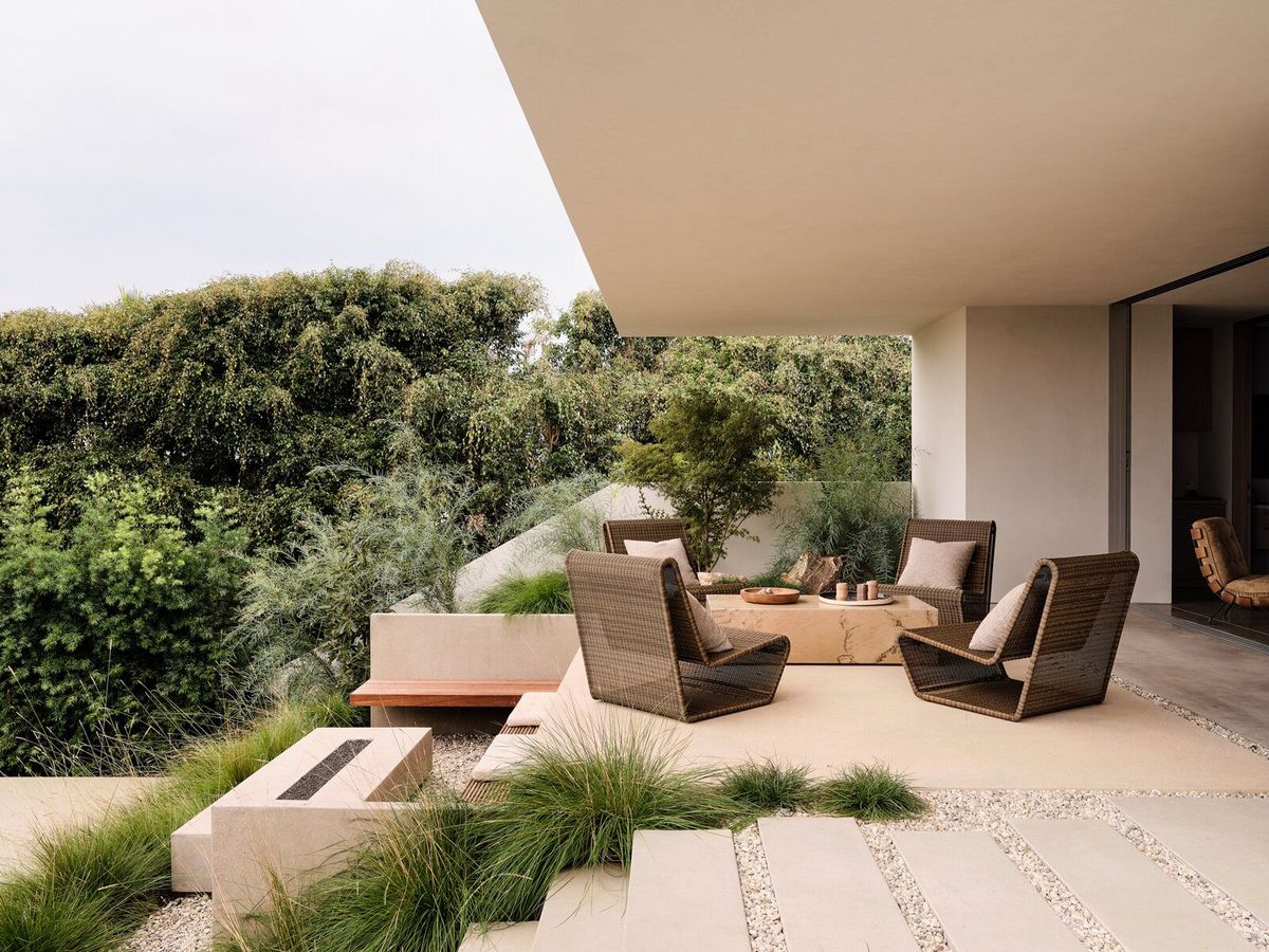 Modjeska: Terrace with woven lounge chairs and a fire table among native grasses