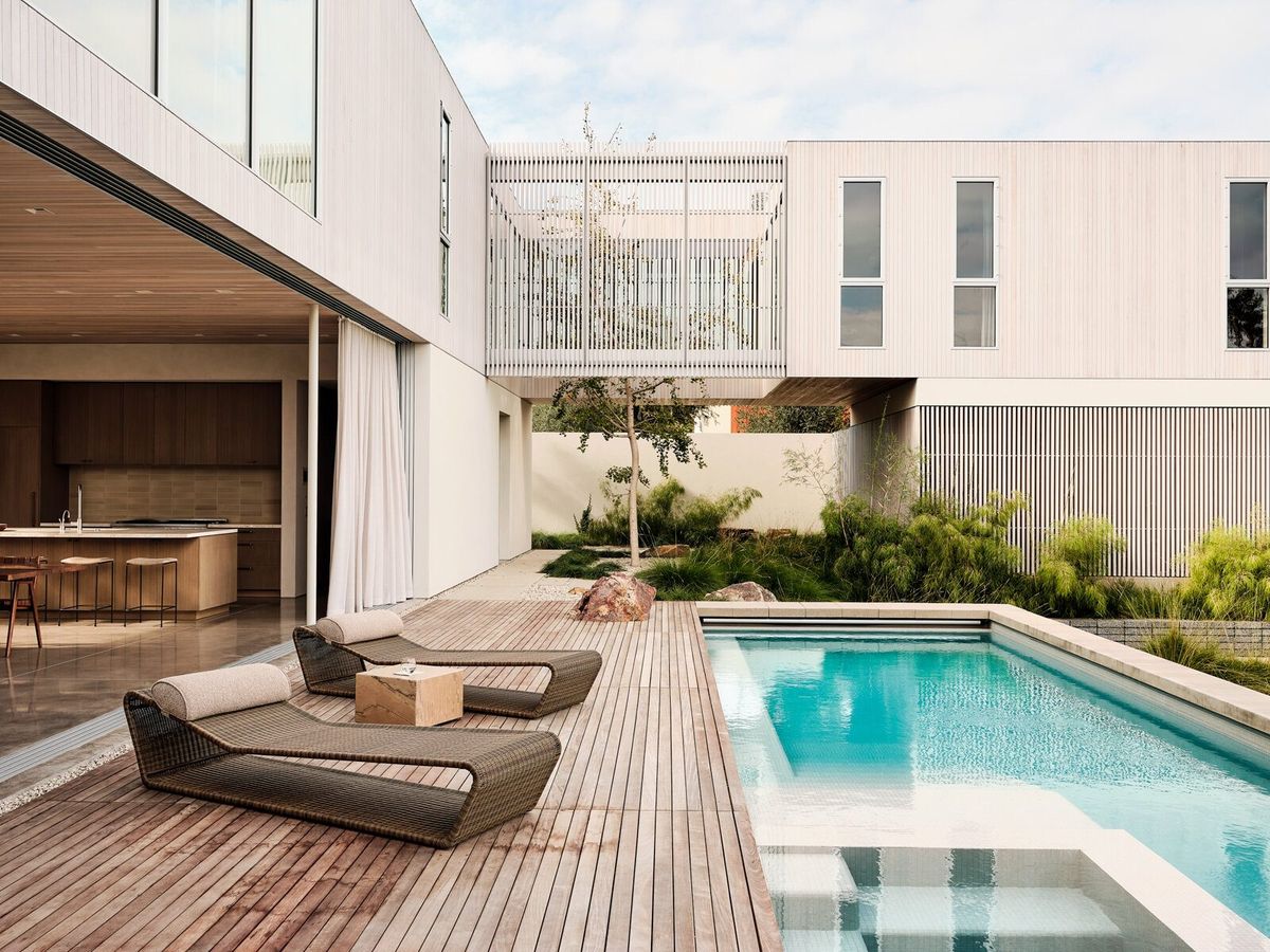 Modjeska: Pool deck with lounge chairs beside the two-story house
