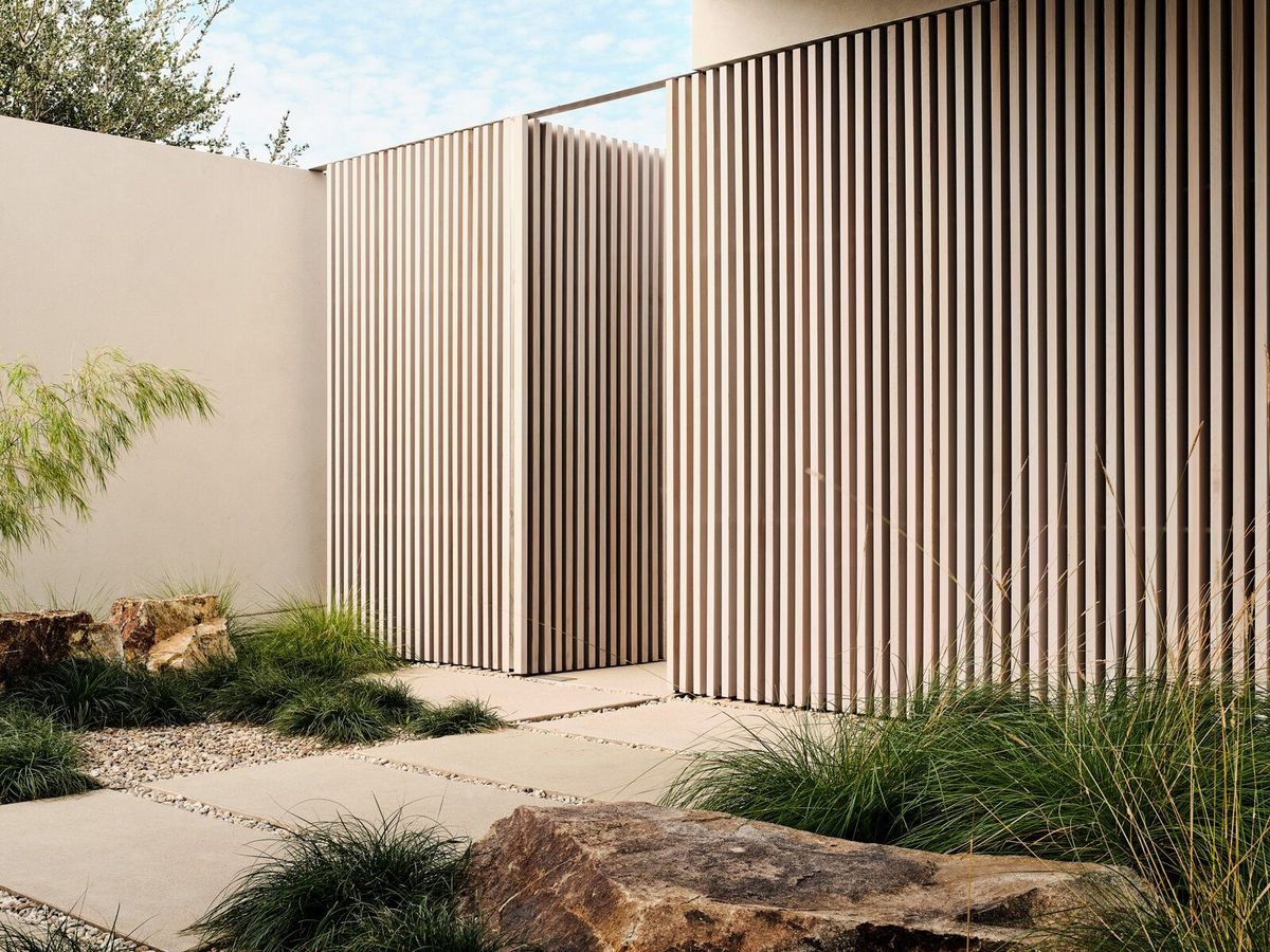 Modjeska: Entry walk of concrete pavers past tall cedar louvers
