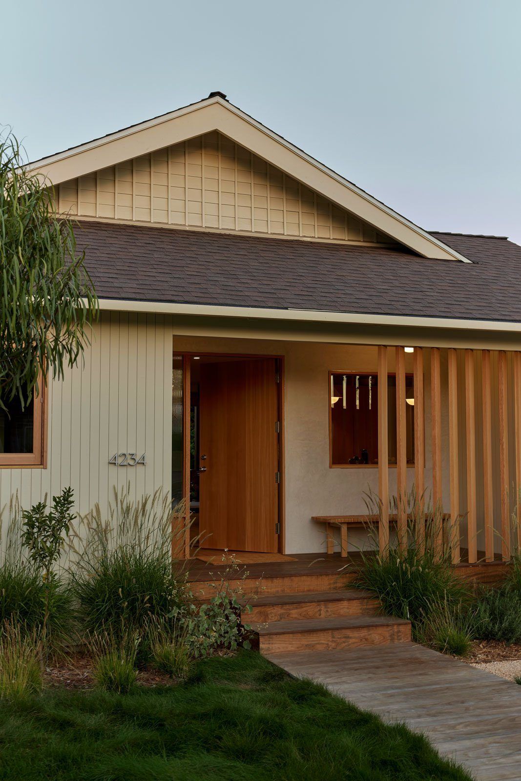 Stewart: Bungalow porch with wood steps, vertical wood screen and white siding