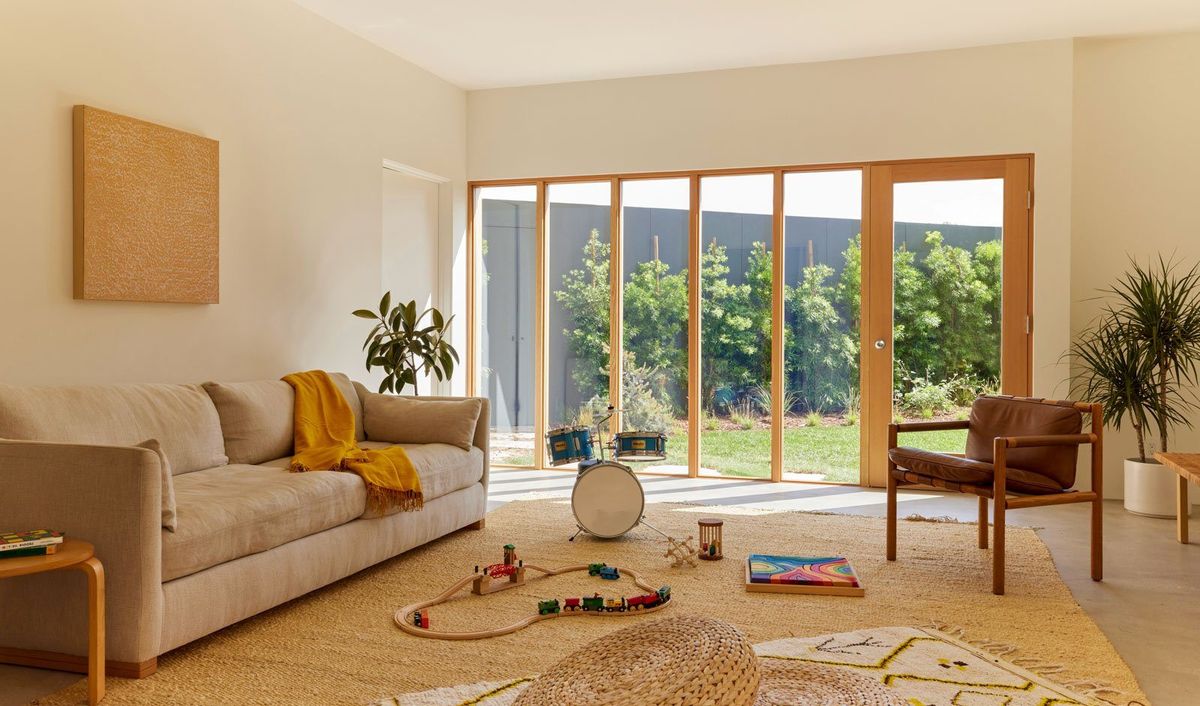 Stewart: Family room with a sofa and toys before a wall of wood-framed doors