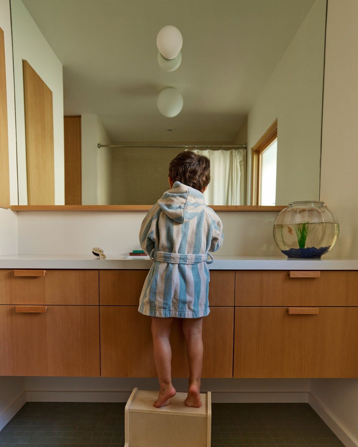 Stewart: Bathroom with a fir vanity and a child at the sink